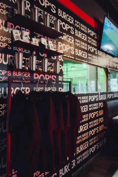 POPs-Burger-Shirts und Trinkbecher als Merchandise